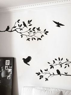 the birds are sitting on the tree branch wall decals in this living room with white walls