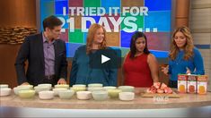 three women and one man standing in front of a table with food on it