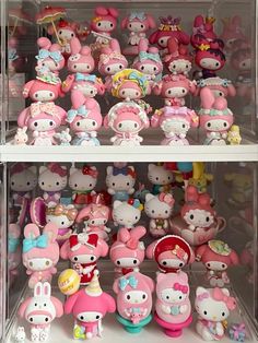 many hello kitty toys are on display in a case