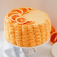 there is a cake with oranges on top and icing in the shape of curls