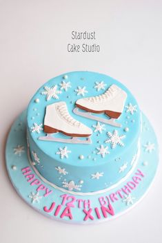 a birthday cake with ice skates on top and snowflakes around the edges