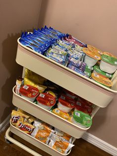 an open cart with food on it in a corner next to a wall and hardwood floor