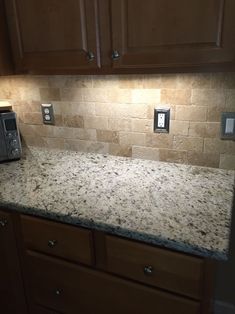 a granite counter top in a kitchen with wooden cabinets