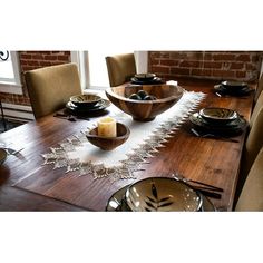 a wooden table topped with plates and bowls