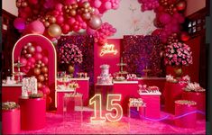 a pink and gold birthday party with balloons on the wall, cake table and decorations