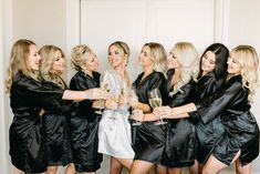 a group of women standing next to each other holding wine glasses