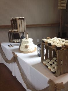 some cupcakes are sitting on a table with white cloth and brown ribbon around them