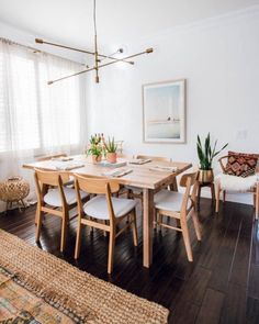 a dining room table and chairs in front of a window