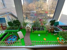 an indoor play area with fake grass and plants in the window sill, along with toys