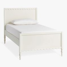 a white bed with an upholstered headboard and foot board on the side