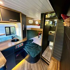 the interior of an rv with wood flooring and black cabinets, including a sink