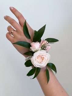 a person's hand with a flower wrist corsage