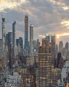 the city skyline is lit up at night, with skyscrapers in the foreground