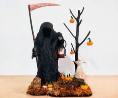 a halloween scene with a scarecrow and pumpkins on the ground, next to a tree