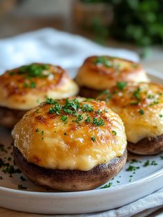 three cheese stuffed mushrooms on a plate with parsley sprinkled on top, ready to be eaten