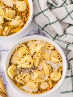 two bowls filled with pasta and meat soup