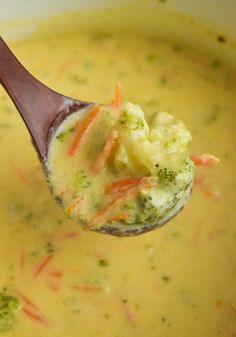 a spoon full of broccoli soup with carrots and celery in it