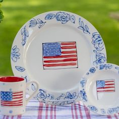 an american flag plate and two cups on a checkered table cloth