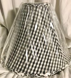 a black and white gingham lamp shade with clear plastic covering on the bottom