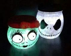 two lighted pumpkins with faces on them in the dark, one is green and the other is white