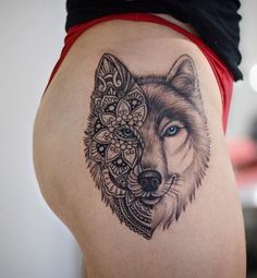 a woman's thigh with a tattoo of a wolf and flowers on the side