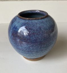 a blue vase sitting on top of a white table