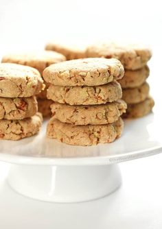 a stack of cookies sitting on top of a white cake plate