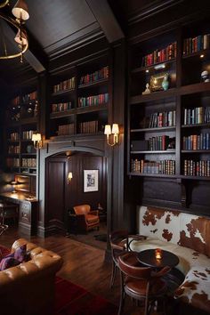 the library is full of books and leather furniture