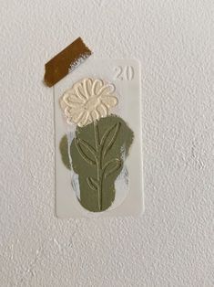 a piece of paper that has some type of flower on it with a brown sticker attached to it