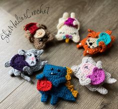 small crocheted animals sitting on top of a wooden table next to each other