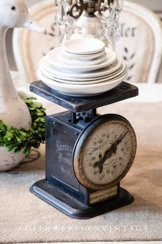 an old fashioned clock sitting on top of a table next to a duck figurine