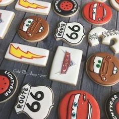 cookies decorated to look like cars and road signs are arranged on a wooden table top