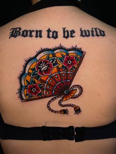 a woman with a tattoo on her back that says born to be wild and an umbrella