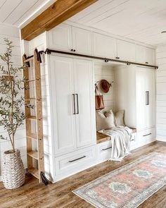 a living room with white walls and wooden flooring, built - in storage units