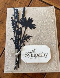 a close up of a card with a flower on the front and a tag that says sympathy