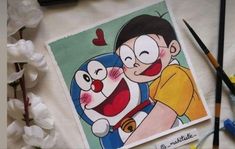 a drawing of two cartoon characters on a table with crayons and markers next to it