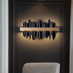 a black and white checkered chair in front of a wall mounted shelf with lights on it