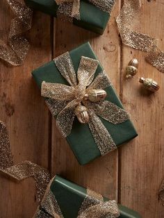 two presents wrapped in green and gold ribbon