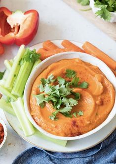 a white plate topped with carrots, celery and dip