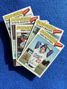 three baseball cards sitting on top of a blue blanket