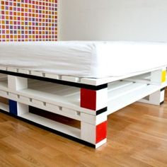 a bed that is made out of pallets on top of each other in a room