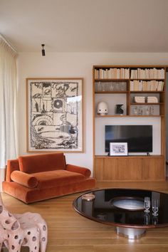 a living room filled with furniture and bookshelves on top of wooden flooring