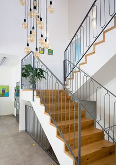 the stairs are made of metal and wood with glass globes hanging from each handrail