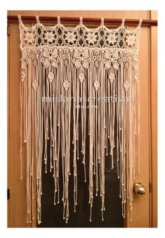 a white curtain hanging from the side of a door with crochet on it