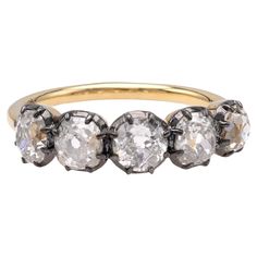 an antique five stone ring with three diamonds in the middle and four smaller stones on each side