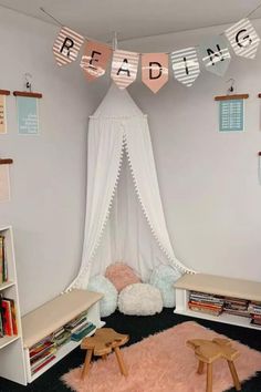 a room that has some bookshelves and pink rugs on the floor in front of it