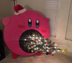 a christmas tree is in the shape of a pink pig with lights on it's nose