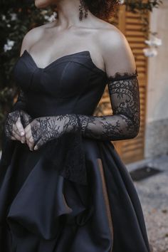 a woman wearing a black dress and gloves