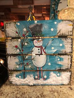 a wooden sign with a snowman painted on it