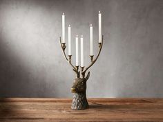 a deer head candle holder with five candles in the shape of a candelabra